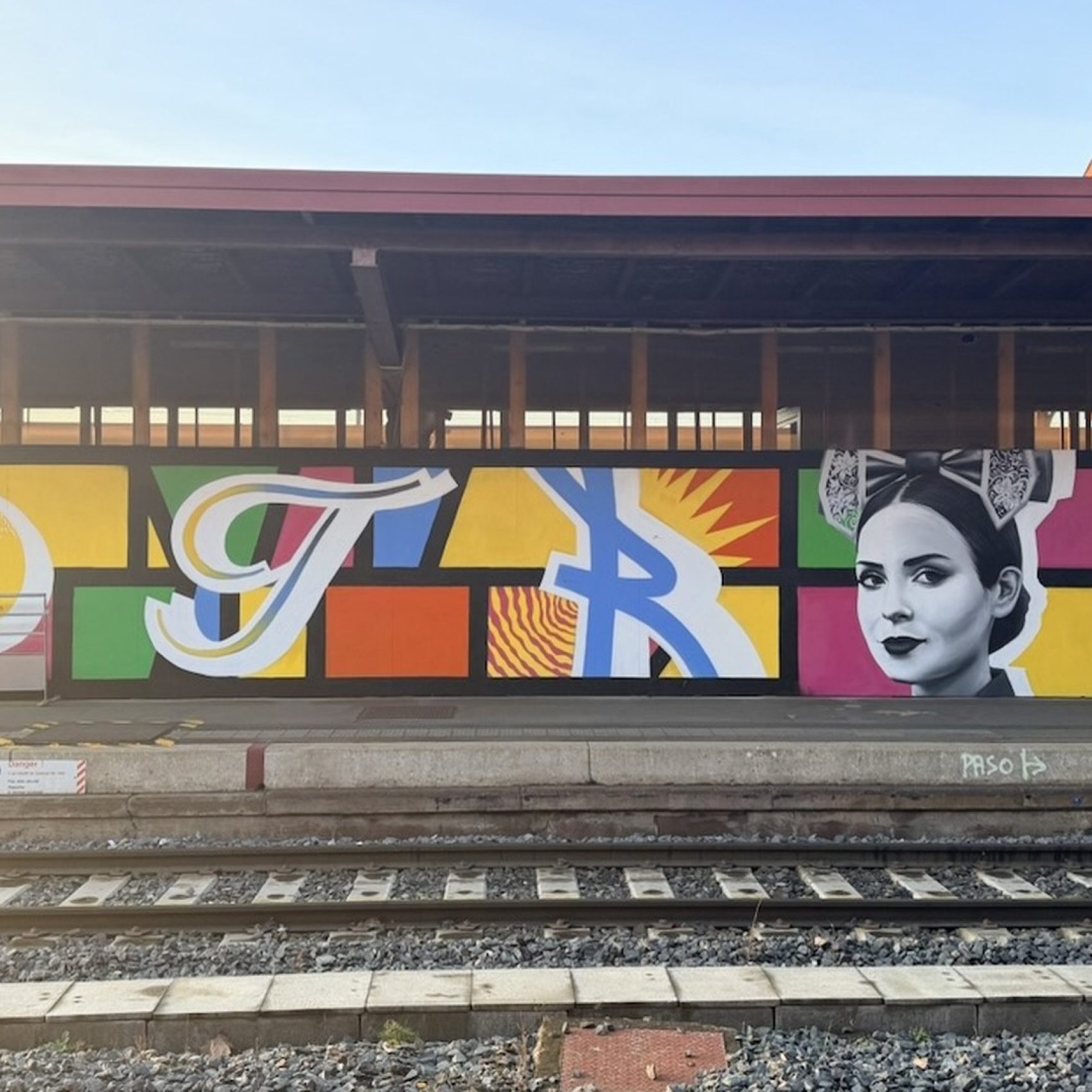 Fresque d'Amoor en gare de Strasbourg : portrait réaliste d'une Alsacienne et lettres STRAS sur colombages pop art, 2025